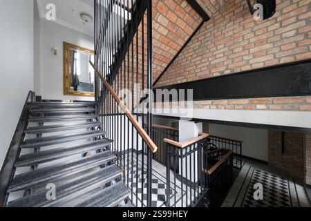 Modern Staircase with Brick Wall and Gold Mirror Stock Photo
