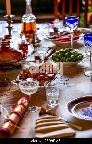 Festive Holiday Dinner Table with Elegant Dishes, Crystal Glassware, and Seasonal Decor Stock Photo