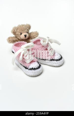 Baby shoes and teddy bear, white background Stock Photo
