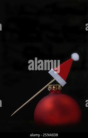 Red Christmas bauble and Christmas hat on a toothpick Stock Photo