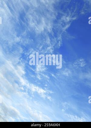 Large scattered veil clouds Cirrostratus clouds in front under blue sky, international Stock Photo