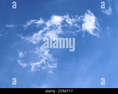 Small white cirrostratus clouds in front under blue sky, international Stock Photo