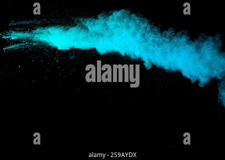 Abstract green blue powder explosion on black background. Blue dust on dark Stock Photo