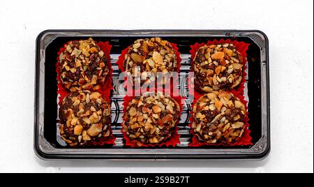 Chocolate dessert balls rolled in hazelnuts in box isolated on white background Stock Photo