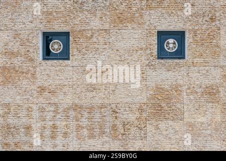 tiled exterior wall with small windows and air vents Stock Photo