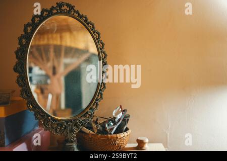 An old round mirror in a decorative frame in the baroque style, the room can be seen in the reflection. Stock Photo