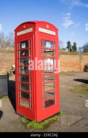 red BT, British telecom phone box out of use outside the brick wall of Greenwich Park Stock Photo