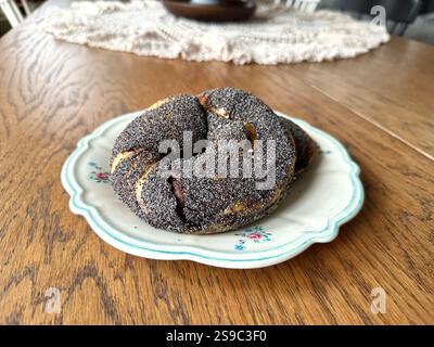 Acma pogaca buns with poppy seeds with olive paste in plate on wooden table Stock Photo