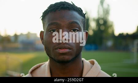 Male athlete portrait cheerful smiling ethnic young sportsman African American man athletic fit guy footballer runner outdoors in morning sunrise Stock Photo