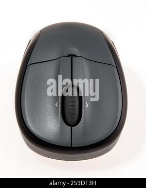 A modern white wireless computer mouse rests on a white background ...