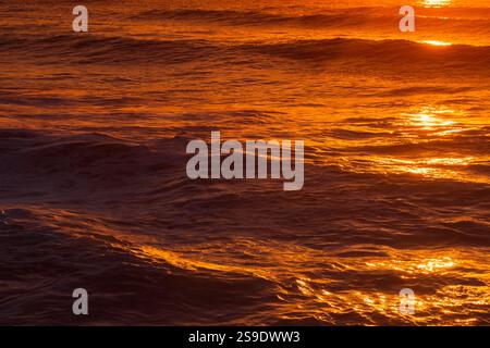 Texture of the water surface wave against a colorful Purple and Orange reflection color on the Atlantic Ocean Stock Photo