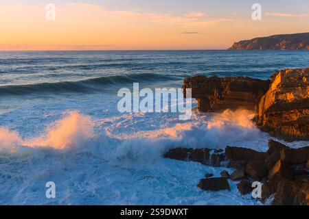 Scenic view of the Atlantic Ocean Coast Blue Big Waves Splashing in Sunset in Praia do Guincho, Cascais Stock Photo