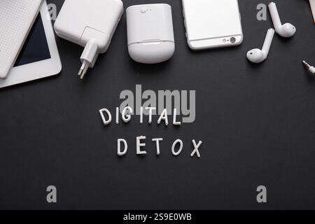 Text DIGITAL DETOX and different gadgets on dark background Stock Photo