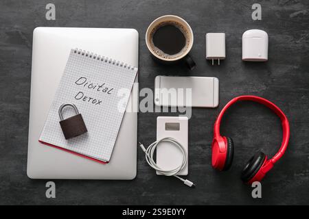 Set of different modern gadgets, notebook with text DIGITAL DETOX and cup of coffee on dark background Stock Photo
