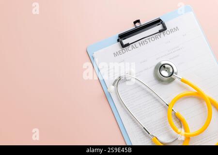 Celebrate Doctor Day with a clipboard holding a medical history form and a yellow stethoscope resting on it. Honoring doctors dedication to health, me Stock Photo