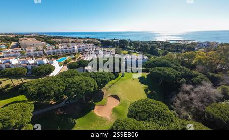 Aerial drone photo of a beautiful golf course in the town of Cabopino in Marbella Costa del Sol Spain with the ocean in the background and golfers on Stock Photo