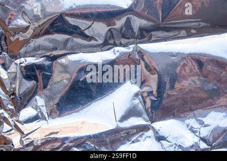 Crumpled reflective shiny gift wrapping material texture background Stock Photo