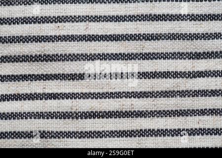 Striped fabric texture with black and white woven lines, showcasing a rustic and natural design. Perfect for backgrounds, textiles, or decorative purp Stock Photo