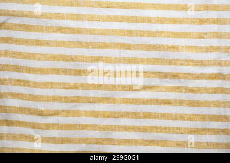 Yellow and white striped fabric with a rustic, woven texture. A seamless, natural pattern ideal for backgrounds, textiles, or decorative designs Stock Photo