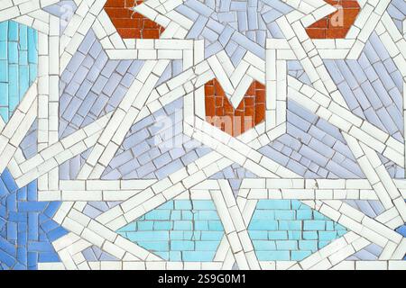 Islamic mosaic with geometric patterns, vibrant colors, and symmetry. Blue, white, red tiles reflect craftsmanship and cultural heritage. Common in mo Stock Photo