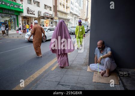 Mecca, Saudi Arabia - June 13, 2024: People sitting and walking near highway in Makkah, Saudi Arabia. Hajj 2024. Stock Photo