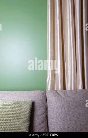 Sofa with pillows and a green wall in the background Stock Photo