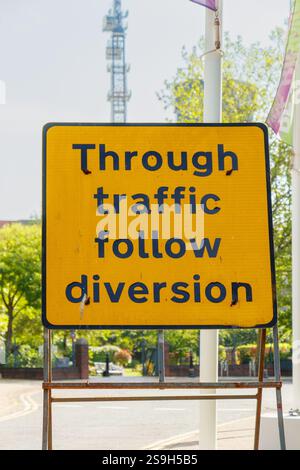 yellow warning sign "Through traffic follow diversion" in street in birmingham uk Stock Photo