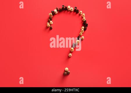 Question mark made of chess pieces on red background Stock Photo