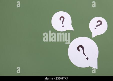 Speech bubbles with question marks on green background Stock Photo