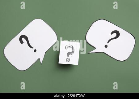 Speech bubbles with question marks on green background Stock Photo