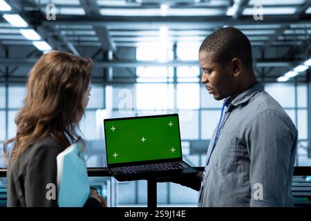 Mockup notebook used by data center system administrators reviewing equipment diagnostics. Close up of chroma key device used by team of IT specialists adjusting server farm configurations Stock Photo