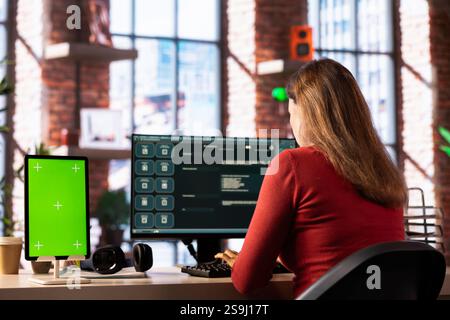 Freelancer interacting with smart AI virtual assistant next to mockup screen, using innovative chatbot web interface. Machine learning enhances productivity through advanced algorithms. Stock Photo