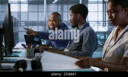 Data center engineers maintaining company network infrastructure by installing, configuring, troubleshooting and repairing hardware. Server hub workers ensuring optimal system performance, camera A Stock Photo