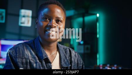 Entrepreneur working at home office desk on laptop, browsing the internet and writing in notebook. Woman using pen, notepad and digital device while teleworking, camera B Stock Photo