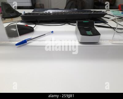 Public service conter with fingerprint scanner, pen and other office objects on a white desk. Stock Photo