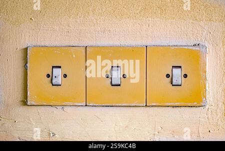 Three Old Plastic Light Switches On A Grunge Dirty Wall Stock Photo