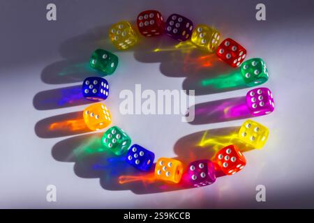 transparent colored dice on paper with shadows Stock Photo