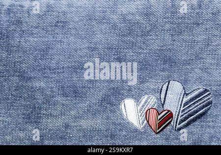 Light blue denim background with felt heart. Horizontal blue color denim jeans fabric texture with heart-shaped textile patch. Valentine's day denim b Stock Photo