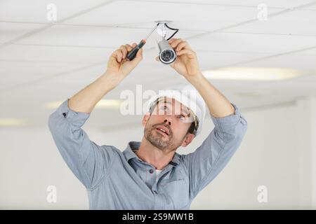 technician installing cctv system in elevetor area Stock Photo