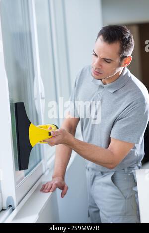 man using window vac to clean windows Stock Photo