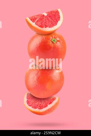 Fresh grapefruits in air on pink background Stock Photo