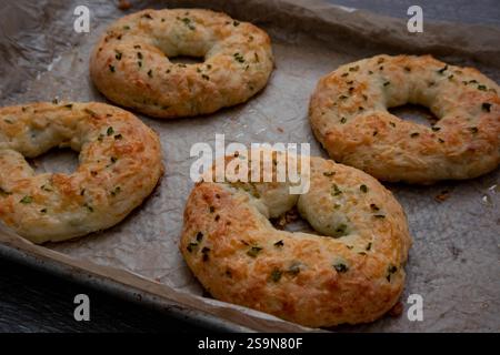 Close-up baked four homemade jalapeno cheese bagels, parchment paper. Stock Photo