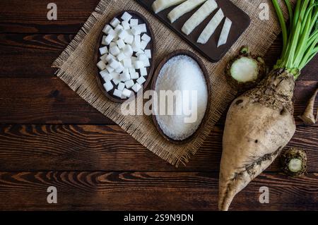 Granulated and cube sugar in bowl with fresh raw sugar beetroot on wooden table, beta vulgaris Stock Photo
