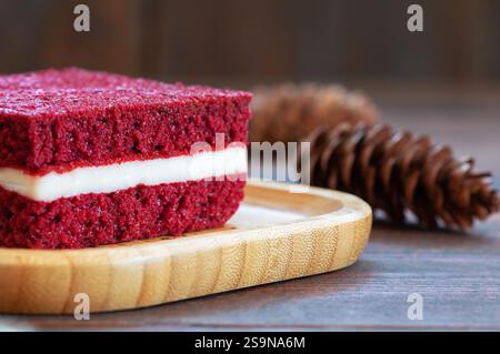 Piece of red velvet cake in plate on rustic table, square sliced, copy space selective focus Stock Photo