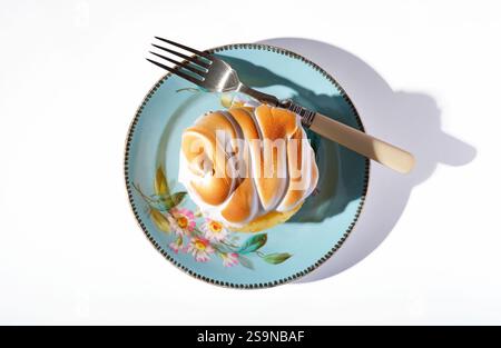 overview of lemon meringue pie on green decorative floral plate Stock Photo