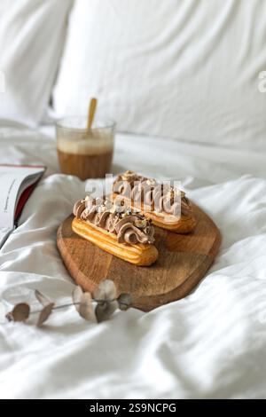 Eclairs with chocolate cream cheese and hazelnuts. breakfast in bed Stock Photo