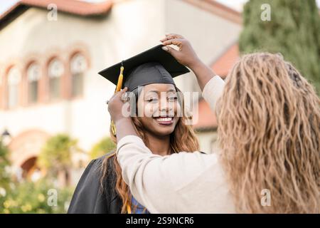 Mother of graduate fixing cap on daughter Stock Photo