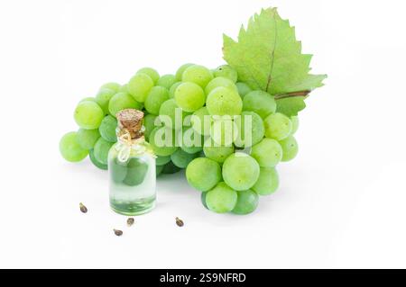 Glass bottle of grape seed oil with fresh green grape fruit isolated on white background Stock Photo