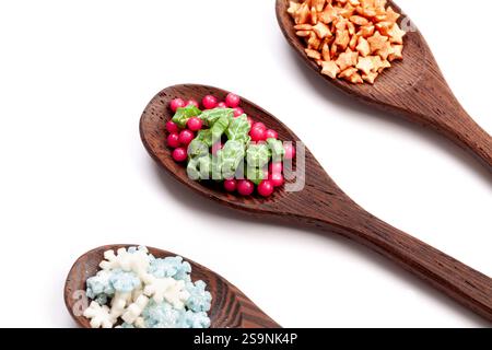Wooden spoons with christmas cake sprinkles on isolated on a white background. space for text Stock Photo
