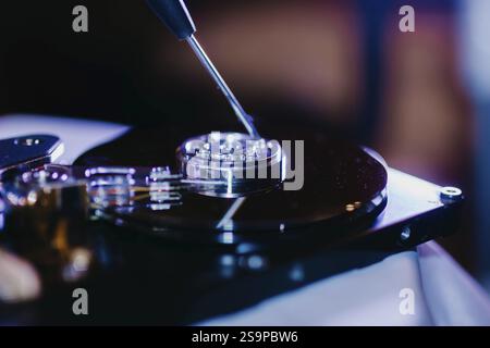 A screwdriver placed into a component of an open hard drive Stock Photo